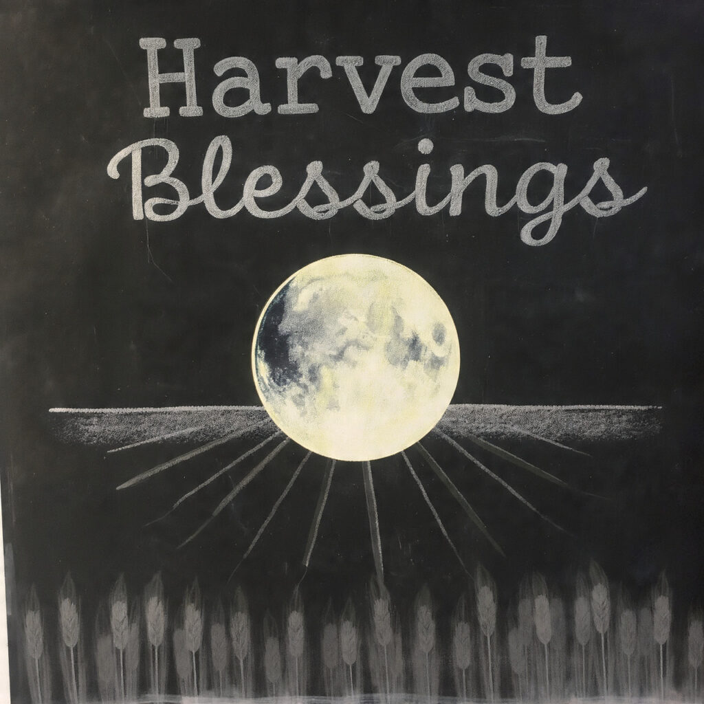 a chalkboard with a large harvest moon